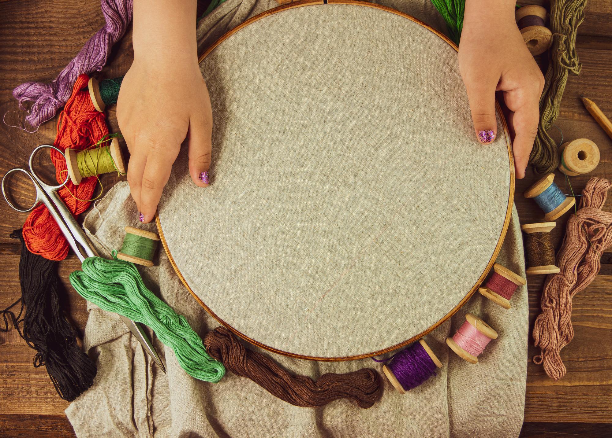 hands arranging embroidered patches on table